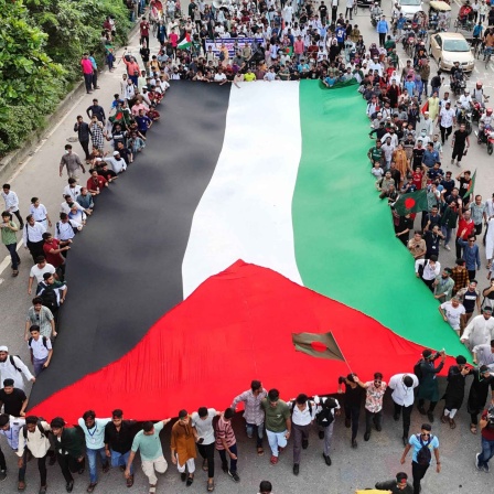 Demonstranten schwenken die Nationalflagge Bangladeschs während einer Kundgebung am 5. September 2024 in Dhaka, einen Monat nach dem Sturz der ehemaligen Premierministerin Sheikh Hasina.