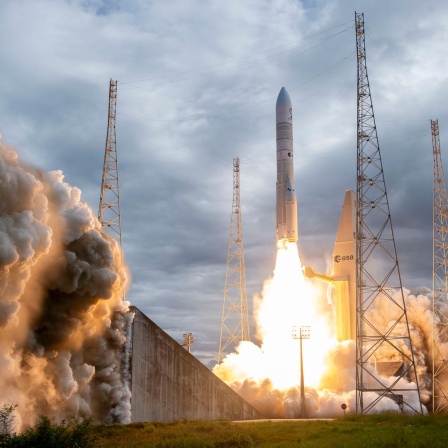 Eine europäische Rakete des Typs Ariane 6 im Augenblick des Starts. Sie hebt mit Feuer und Rauch ab.