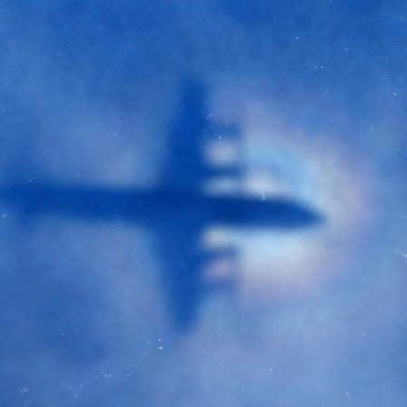 Schemenhaftes Flugzeug am leichtbewölkten Himmel