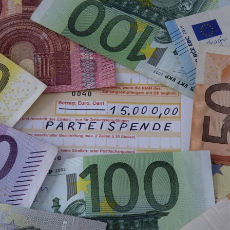 Geldscheine liegen auf einem Überweisungsschein, 15.000 Euro Parteispende, Symbolbild