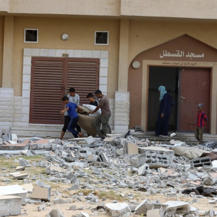 Palästinenser fliehen mit ihren Besitztürmern aus einem Haus im Gaza-Streifen.
