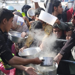 Menschen in Rafah stehen für Lebensmittel an.