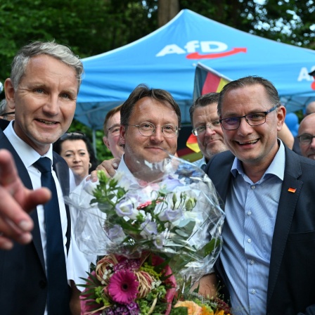 Björn Höcke, Vorsitzender der AfD Thüringen, und Tino Chrupalla, AfD-Bundesvorsitzender, gratulieren dem Wahlsieger des Thüringer Kreis Sonneberg, Robert Sesselmann (AfD), im Garten eines Restaurants.