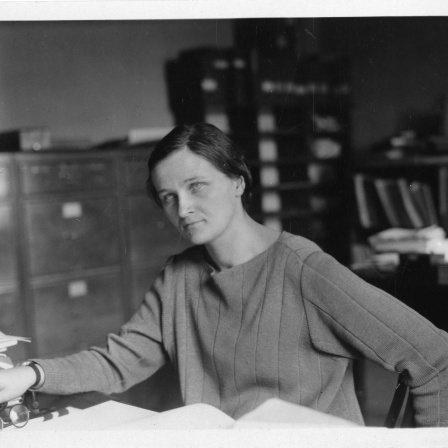 Schwarz-weiß-Aufnahme von Cecilia Payne an einem Schreibtisch sitzend