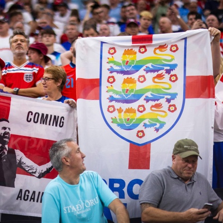 Englische Fans zeigen eine Flagge mit den "Three Lions" in Regenbogenfarben bei der Fußball-WM in Katar.