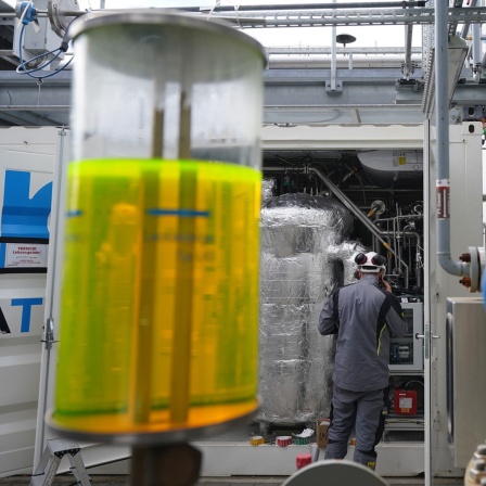 Ein Mitarbeiter überprüft die neue Power-to-Liquid-Demonstrationsanlage auf dem Gelände der Raffinerie H&R Ölwerke Schindler GmbH im Hamburger Hafen. 