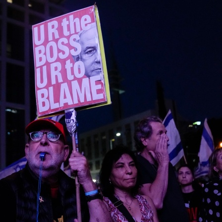 Tel Aviv: Ein Mann hält ein Schild mit einem Bild des israelischen Premierministers Netanjahu während einer Demo