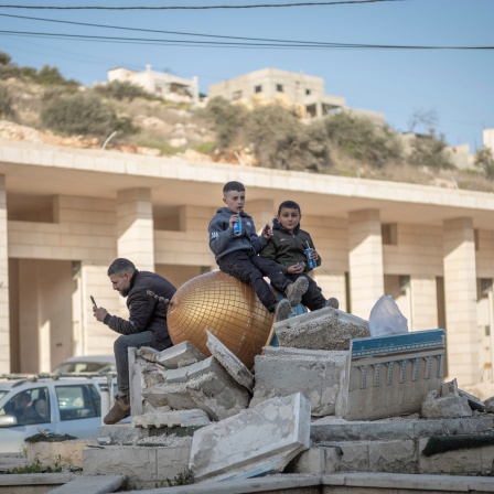 Palästinensische Jungen sitzen auf einer zerbrochenen Skulptur des Jerusalemer Felsendoms, der von israelischen Streitkräften bei einer Militärrazzia in Qabatiya im Norden des besetzten Westjordanlands zerstört wurde.