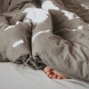Füße gucken unter einer Bettdecke hervor
