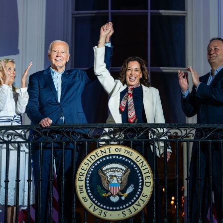 Präsident Joe Biden und Vize-Präsidentin Kamala Harris halten auf dem Balkon des weißen Hauses gemeinsam ihre Hand hoch.