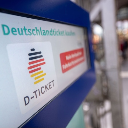 Ein Hinweis für das Deutschlandticket steht auf einem Fahrkartenautomaten.