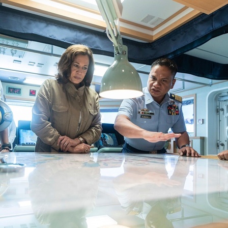 US-Vizepräsidentin Kamala Harris blickt mit Offizieren der philipppinischer Küstenwache auf eine Karte.