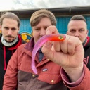 Eric hält seinen ersten, eigenhändig hergestellten Gummiköder in der Hand - natürlich dank der Hilfe von den Jungs von MR Baitz Robert(links) und Michael(Bild: rbb/F. Rößler)
