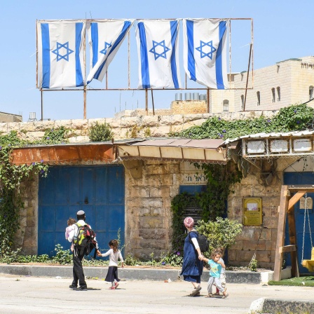 Jüdische Siedlerfamilie geht durch eine vormals palaestinensische Straße