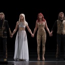 Die Avatare der Abba-Bandmitglieder Björn, Agnetha, Anni-Frid und Benny stehen nebeneinander auf der Bühne und halten einander an den Händen.