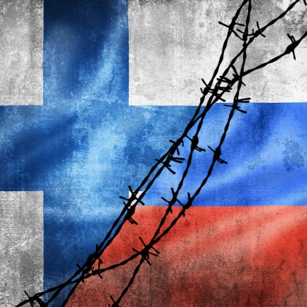Eine Collage der finnischen und russischen Flaggen mit Stacheldraht