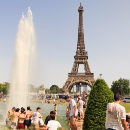 Hitzewelle mit Temperaturen bis zu 42°C in Frankreich in Paris am 18. Juni 2022. Menschen baden im Springbrunnen vor dem Eiffelturm.