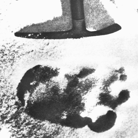 Das Archivbild von 1951 zeigt eine Spitzhacke, die auf einen großen unidentifizierten Fußabdruck im Schnee des Himalaya deutet. Eine Expedition stieß 1951 auf den Abdruck und schrieb ihn dem sagenumworbenen Schneemenschen Yeti zu.