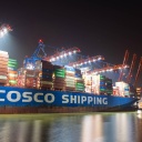 Das Containerschiff Cosco Shipping Aries des chinesischen Unternehmens Cosco China Ocean Shipping Company liegt in der Nacht am Container-Terminal Tollerort der HHLA im Hamburger Hafen.
