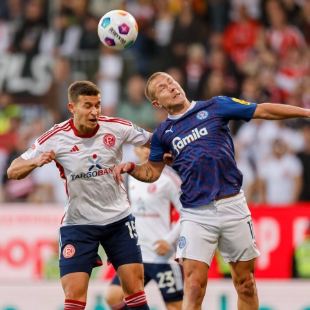 Düsseldorfs Tim Oberdorf (l.) im Kopfballduell mit Lewis Holtby (r.).