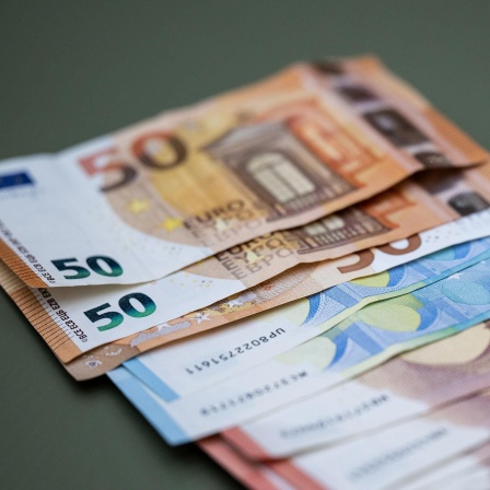 Zahlreiche Euro-Banknoten liegen auf einem Tisch.