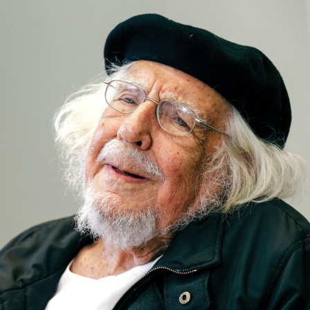 Ernesto Cardenal trägt eine Baskenmütze und lächelt in die Kamera