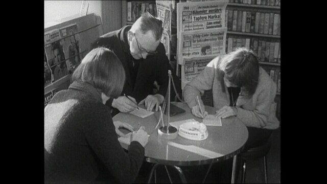 Zwei Lottospielerinnen und ein Lottospieler beim Ausfüllen von Tippscheinen in einem Zeitungskiosk (1965)