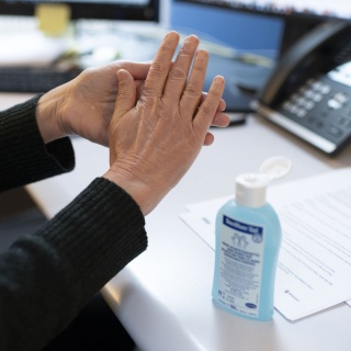 Ein Arbeitnehmer desinfiziert sich im Büro die Hände