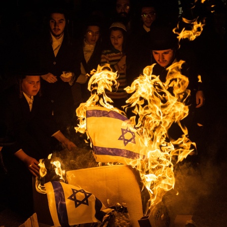 Mitglieder der antizionistischen ultraorthodoxen Gruppe &#034;Neturei Karta&#034; verbrennen israelische Fahnen