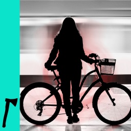 Eine Frau steht mit ihrem Fahrrad an einer U-Bahn-Haltestelle.