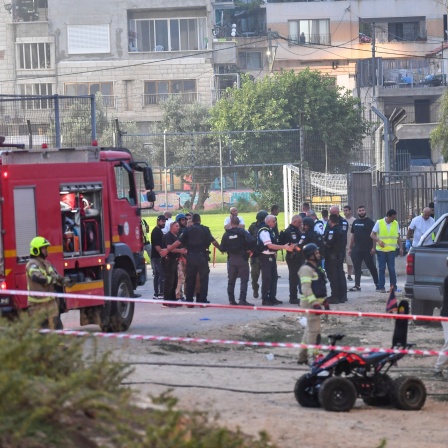 Israelische Polizisten und Feuerwehrleute arbeiten am Ort eines Raketenangriffs auf den israelisch kontrollierten Golanhöhen. 