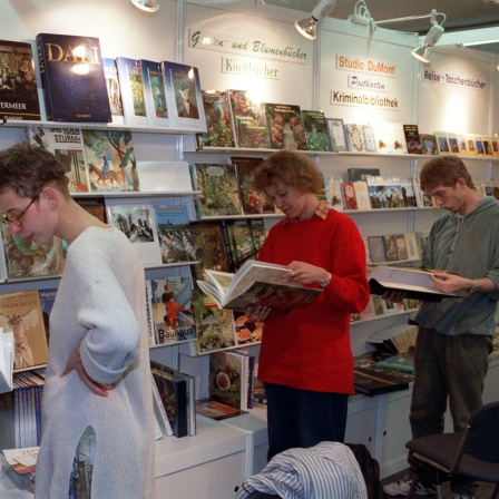 Besucher schauen in Bücher auf der Leipziger Buchmesse, hier 1992 (Archivbild)