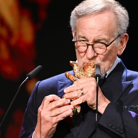 Steven Spielberg küsst nach der Verleihung seinen Goldenen Ehrenbären auf der Berlinale-Bühne.