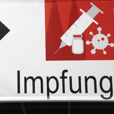 Ein Schild weist den Weg im Impfzentrum in der Messe Köln