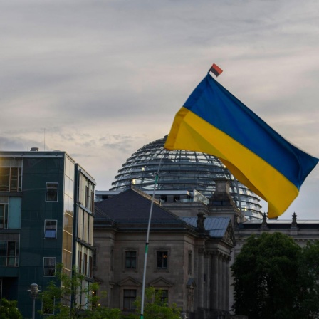 Eine Ukraine-Flagge weht bei einer Demonstration gegen den russischen Angriffskrieg vor dem Bundestag in Berlin (Archivbild)