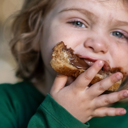 Ein Junge isst einen Toast mit Nutella