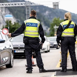 Deutsche Bundespolizisten beobachten an der Grenze zu Österreich auf der Autobahn A93 den Verkehr.