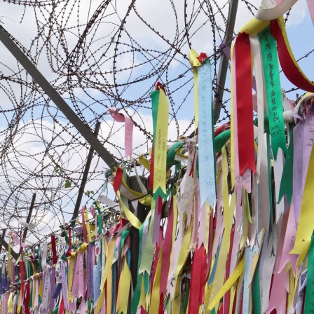 Tausende bunte Baender unter Stacheldraht an der innerkoreanischen Grenze in Paju, Suedkorea.