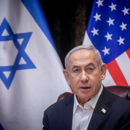 Die Flaggen von Israel und den USA, im Vordergrung sitzt Israels Ministerpräsident Netanjahu