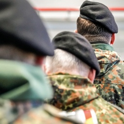 Soldaten der Deutschen Bundeswehr mit Feldmützen und in Soldatenuniform stehen hintereinander.