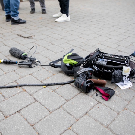 Die Ausrüstung eines Kamerateams liegt auf dem Boden