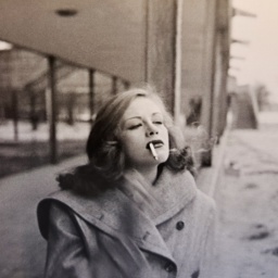 Szene aus dem Dokumentarfilm "Ich will alles. Hildegard Knef": Eine junge Frau mit Zigarette und Mantel geht auf dem Bürgersteig