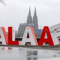 Eine Skulptur mit dem Schriftzug ALAAF am Deutzer Rheinufer im Regen.