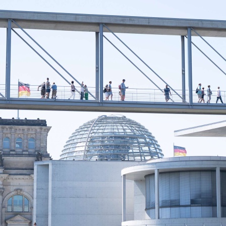 Menschen laufen über den Marie-Elisabeth-Lüders-Steg im Berliner Regierungsviertel. 