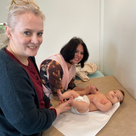 Die Kinderärztin Anne Kistner-Peters untersucht ein Baby, dessen Mutter neben ihr steht.