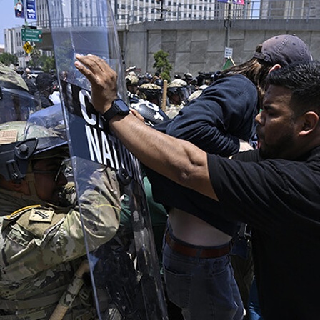 Foto eines Protestierenden in Los Angeles, der inmitten eines Handgemenges zwischen demonstrierenden und Sicherheitskräften im Rahmen der Proteste gegen die Abschiebepolitik Trumps das Schutzschild eines National-Guard-Soldaten wegschiebt
