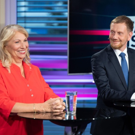 Petra Köpping (SPD), Sozialministerin von Sachsen, und Michael Kretschmer (CDU), Ministerpräsident von Sachsen, stehen vor Beginn der TV-Wahlarena des MDR in einem Saal der Handwerkskammer Dresden nebeneinander.