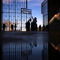 Besucher gehen am "Tag des Gedenkens an die Opfer des Nationalsozialismus" durch das Tor der Gedenkstätte Sachsenhausen in Oranienburg © picture alliance/ AP/ Markus Schreiber 