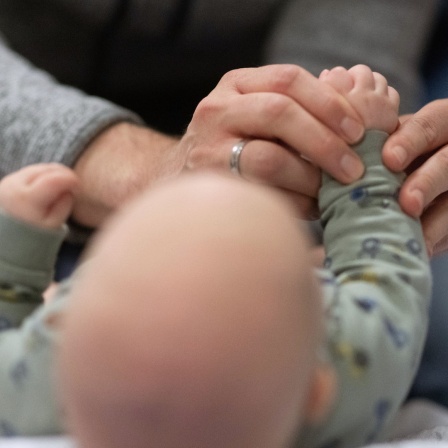 Ein Vater hält die Hand seines Kindes