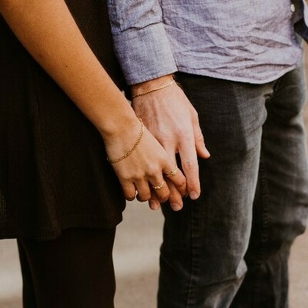 Eine Frau und ein Mann halten Händchen.